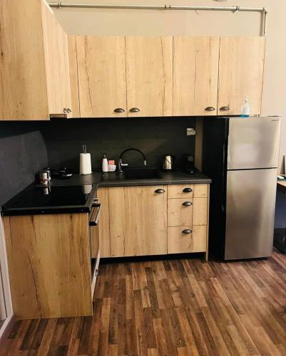 una cucina con mobili in legno e un frigorifero in acciaio inossidabile di City Loft 4 Stamatina's Luxury Apartments a Alexandroupoli