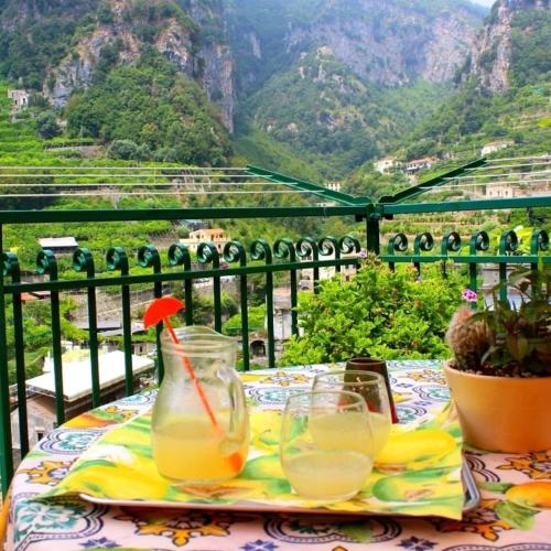 un tavolo con 2 bicchieri di succo d'arancia su un balcone di La Valle Delle Ferriere ad Amalfi