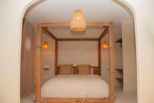 a bedroom with a bed with a wooden frame at Bonica Spa, Exceptionnel, piscine intérieure, spa, sauna et Parking privé in Sallaumines