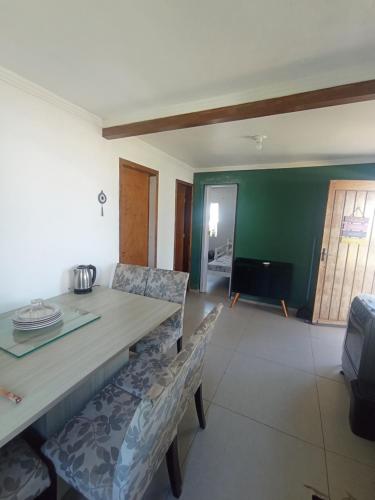 a dining room with a table and two chairs at Casa na Beira da Praia de Capão da Canoa in Capão da Canoa