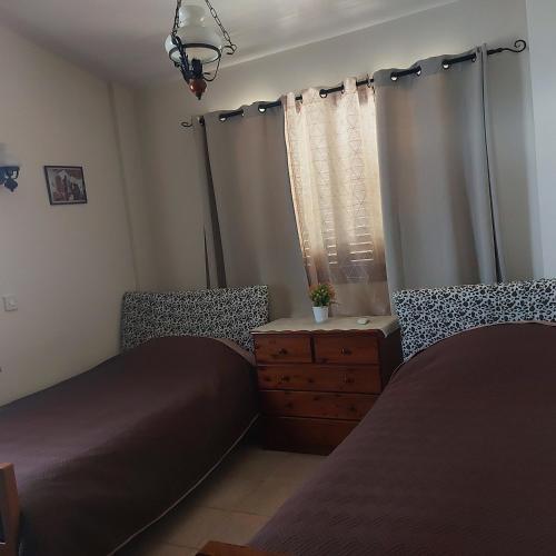 a bedroom with two beds and a window at Agrepavli Lapithia in Kallepia