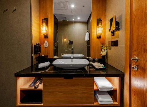 a bathroom with a sink and a mirror at Millennium Al Masar in Jeddah