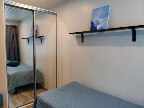 a bedroom with a mirror and a bed and a bed at Hostelli Jokiranta in Lieksa