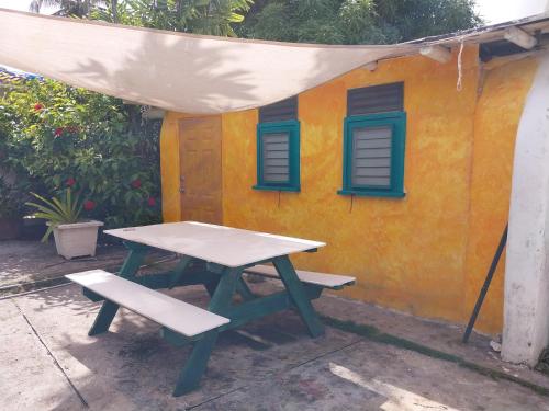 einem Picknicktisch und einer Bank vor einem Haus in der Unterkunft SHAMBHALA Homestays Cottage and Studio in Christchurch