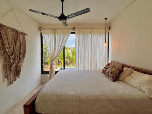 a bedroom with a bed and a ceiling fan at Casa Ola, luxurious jungle house in El Valle