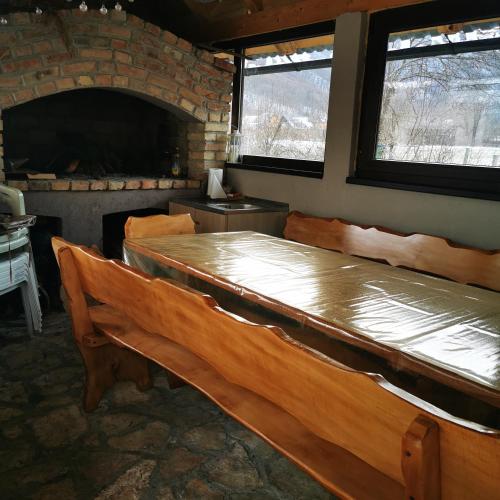 a room with wooden benches in a room with a fireplace at Kuća za odmor Tomislav in Trnovdc