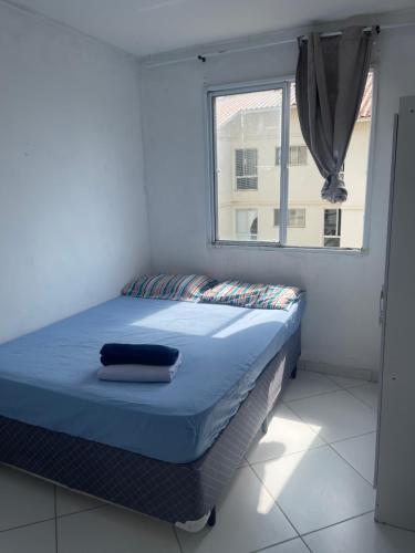 a bed sitting in a room with a window at Apt 2 quartos in Itamaracá
