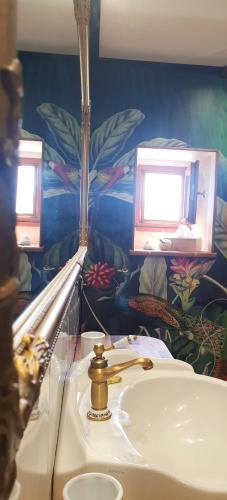a bathroom with a sink and a mirror and a sink at Ets CAPMASIL - chambre 1920 in Virac