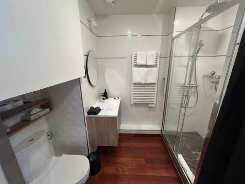 a bathroom with a shower and a toilet and a sink at Le Grand Hôtel Mont Dore in Le Mont-Dore