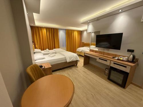 トゥズラにあるEnjoy Suitのベッドとテレビがあるホテルの部屋