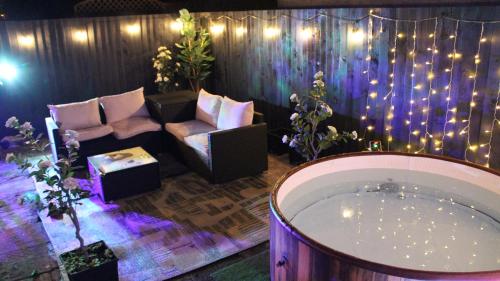 a room with a tub and a chair and lights at Stylish House in Welsh Hills, Sleeps 8 to 12 in Rhondda