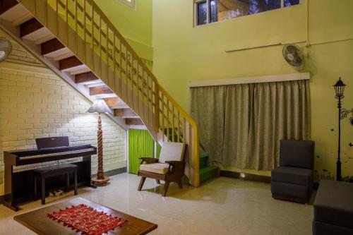 a living room with a staircase and a piano at Grrenwood Flora in Guwahati