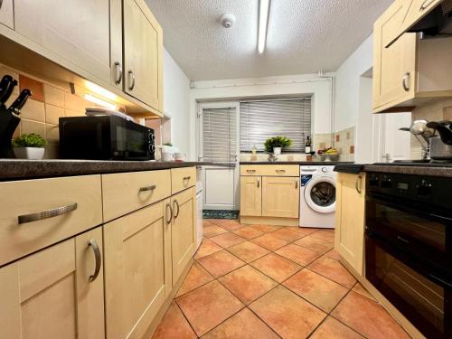 a kitchen with a washer and dryer in it at J&J stays 5 bedroom detached house in Peterborough with parking in Peterborough