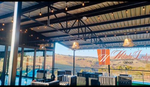 a group of chairs in a building with a view at Ndalo Lodge Oshoek in Oshoek