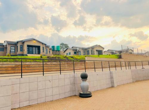 a vase sitting on a wall in front of houses at Ndalo Lodge Oshoek in Oshoek