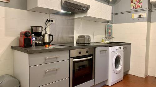 une cuisine avec un lave-linge et un lave-linge dans l'établissement ApartHotel Riviera - COCON BARILLERIE - Old Town - Promenade des Anglais, à Nice