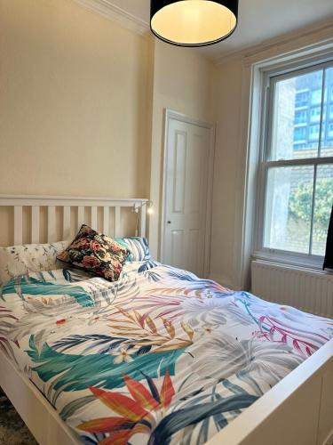 a bedroom with a bed with a colorful comforter at 1 Bedroom Apartment By Guest Nest Management Vacation Rental Brighton - Pet-Friendly in Brighton & Hove