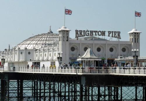 a building on a pier with people on it at 1 Bedroom Apartment By Guest Nest Management Vacation Rental Brighton - Pet-Friendly in Brighton & Hove