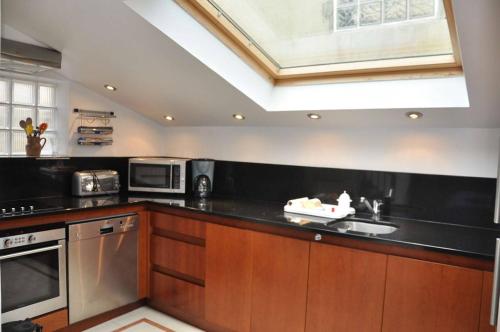 - une cuisine avec un plan de travail noir et un évier dans l'établissement Maison à 100m de la mer avec WIFI, place Ste-Anne à TREGASTEL - Réf 43, à Trégastel