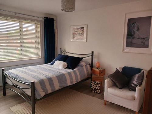 a bedroom with a bed and a chair and a window at 2 bed room house available with free parking in Belfast
