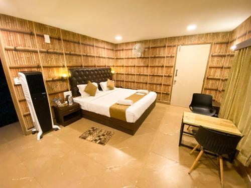 a bedroom with a bed in a room with book shelves at The Mountain Shades Resort in Madikeri