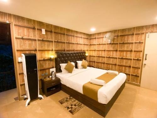 a bedroom with a bed in a room with book shelves at The Mountain Shades Resort in Madikeri