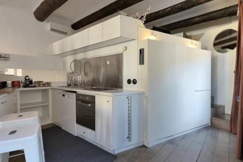 a white kitchen with white cabinets and appliances at Vieux-Port Magnifique Appartement Loft in Marseille