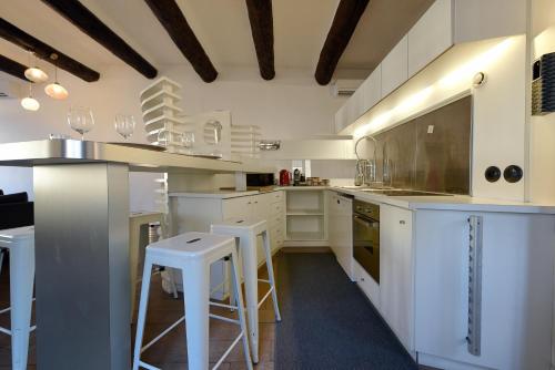 a kitchen with white cabinets and bar stools at Vieux-Port Magnifique Appartement Loft in Marseille