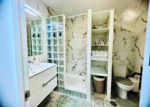 un baño con inodoro y lavabo en Beachfront Gem with Sand and Sea at Your Doorstep, en Santiago del Teide