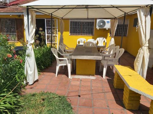 a patio with a table and chairs under an umbrella at Chapadmalal Casas La Bella in Colonia Chapadmalal