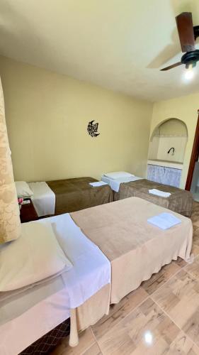 a room with two beds in a room at Pousada Villa Bella in Maricá