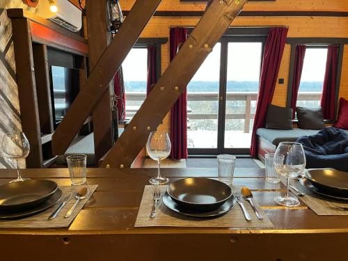 a table with plates and wine glasses on it at Nyerges Vendégház in Verőce