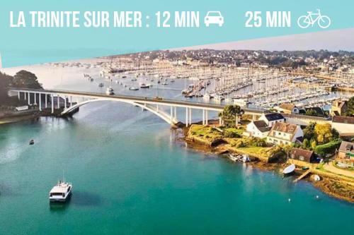 a bridge over a river with a boat in the water at Studio Cosy LES ROSES TREMIERES 3 étoiles centre Plouharnel proche mer in Plouharnel