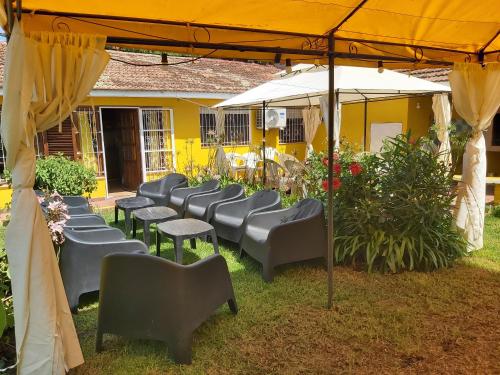 a group of chairs under an umbrella in front of a building at Chapadmalal Casas La Bella in Colonia Chapadmalal