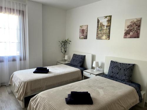 una habitación con dos camas y una ventana en Beachfront Gem with Sand and Sea at Your Doorstep, en Santiago del Teide