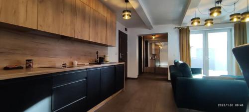 a kitchen with a counter and a living room at Apartamenty Olimpijskie Szczyrk in Szczyrk