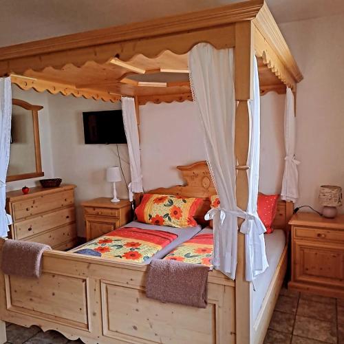 a bedroom with a wooden bed with a canopy at Penzion Montana in Zelená Lhota