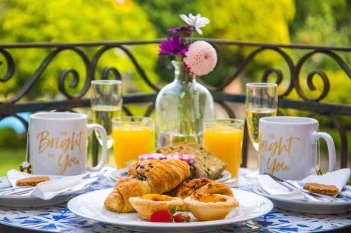 een tafel met borden gebak en glazen sinaasappelsap bij Solar Alegria Lodge in Oliveira de Frades