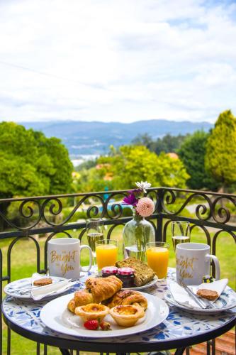 een tafel met borden eten en glazen sinaasappelsap bij Solar Alegria Lodge in Oliveira de Frades