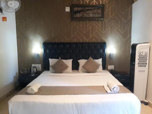 a bedroom with a large bed with white sheets and pillows at The Mountain Shades Resort in Madikeri