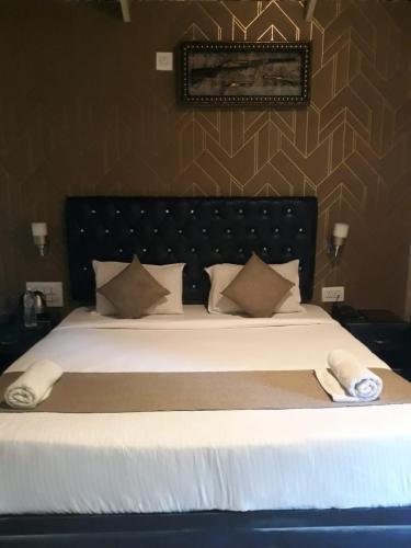 a bedroom with a large bed with white sheets and pillows at The Mountain Shades Resort in Madikeri