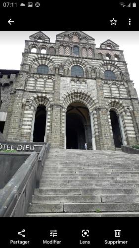 a stone building with stairs in front of it at Maison de village gîte de "La Roche" in Saint-Julien-Chapteuil