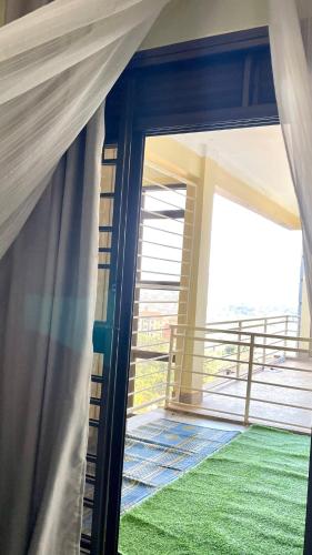 a view of a room with a curtain and a balcony at Rebecca Apartments Kampala in Kampala