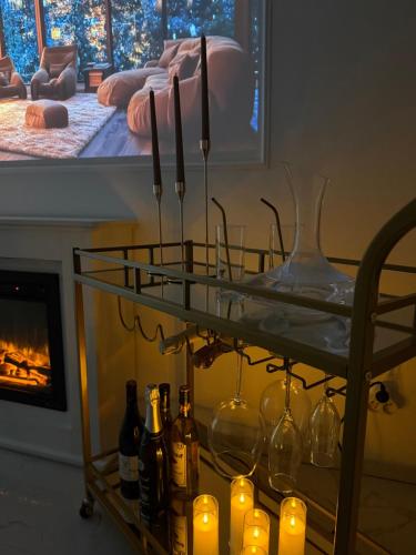 a shelf with wine bottles and candles and a fireplace at HomeyHome Strasbourg in Schiltigheim