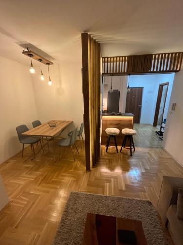 a dining room and living room with a table and chairs at Apartman LAKI in Požarevac
