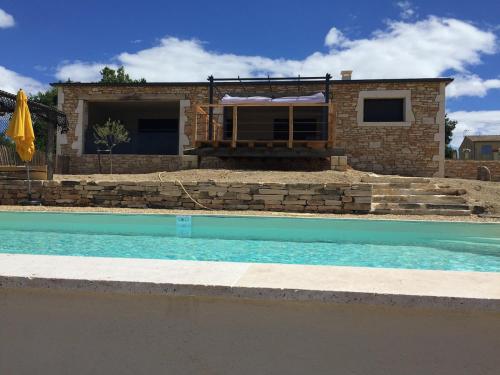 une maison en briques avec une piscine en face de celle-ci dans l'établissement Villa à Barjac piscine chauffée et vue panoramique, à Barjac