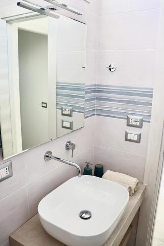 a bathroom with a white sink and a mirror at Nido del Mar in Lendinuso