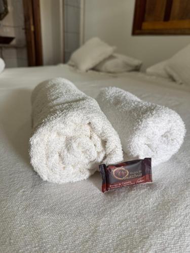 a stuffed animal laying on a bed with a bar of soap at Pousada Flor do Xandó Caraíva in Caraíva