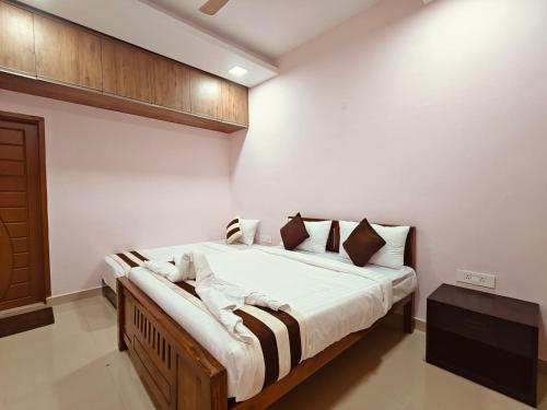 a bedroom with a large bed with white walls at The Whiteglow Elite in Chennai