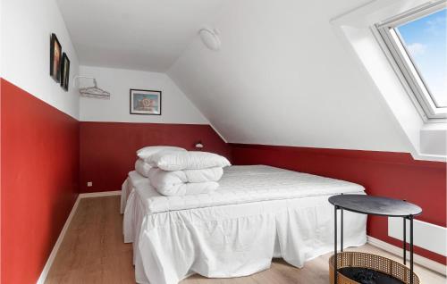 a bedroom with a bed with red walls and a window at Lovely Home In Fejø With Wifi in Østerby